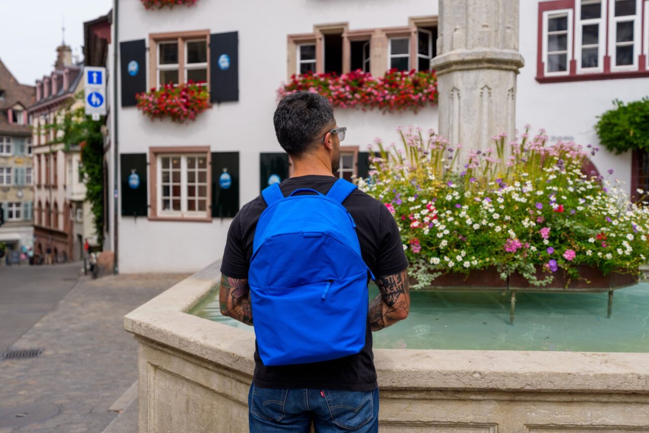 peak design suisse fontaine Peak Design City Backpack 22L Lapis porté de dos devant une fontaine à Bâle