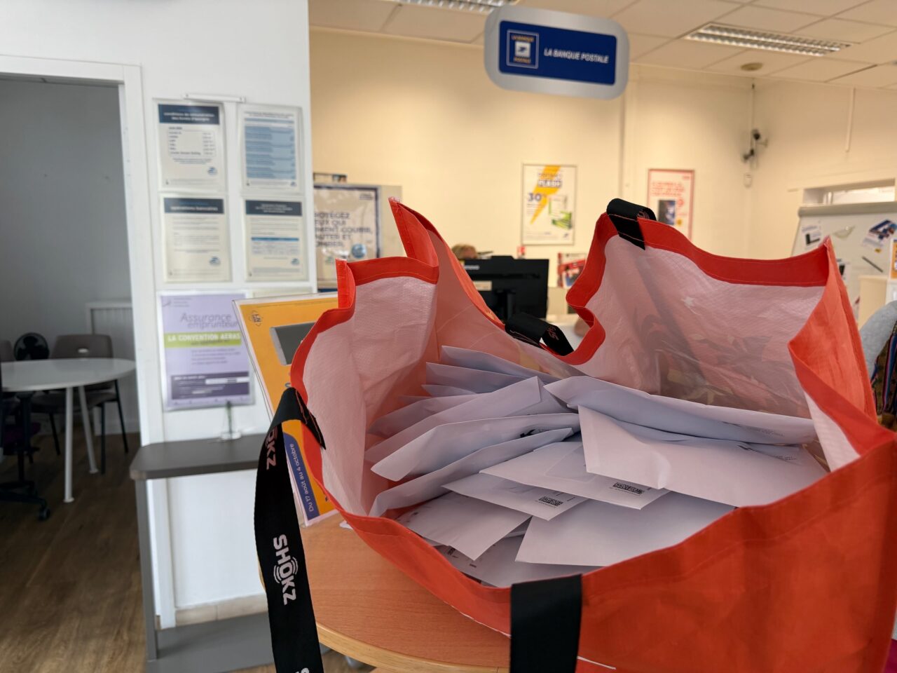 Un grand sac orange rempli d'enveloppes contenant les FULL PACK de flammes au bureau de poste.
