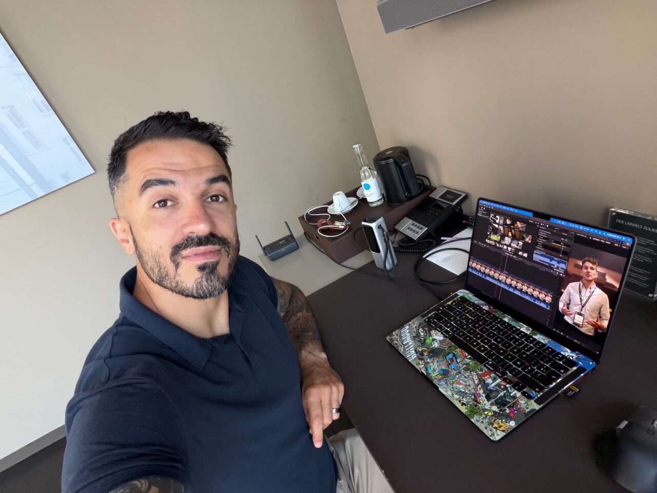 lokan sardari ifa 2026 coulisses LoKan devant son MacBook affichant un montage vidéo sur le bureau de sa chambre d'hôtel.
