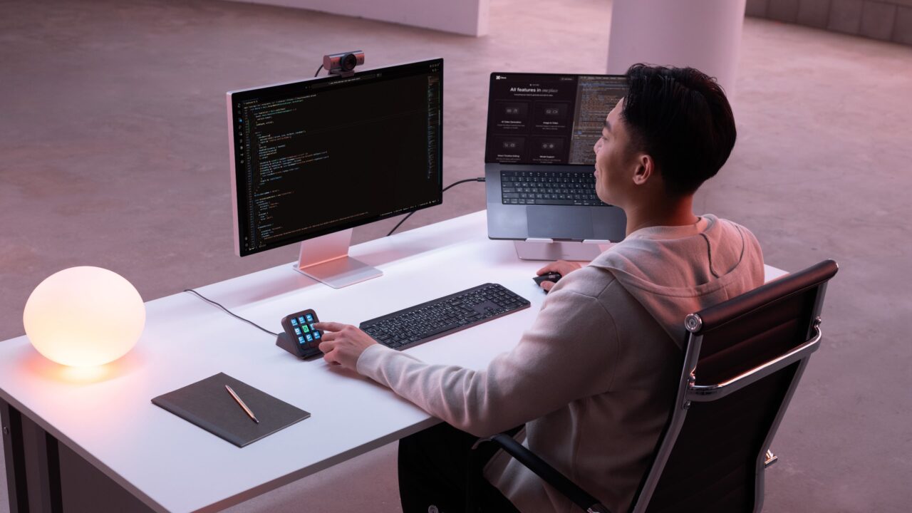Développeur utilisant le Logitech MX Keypad avec deux écrans de code
