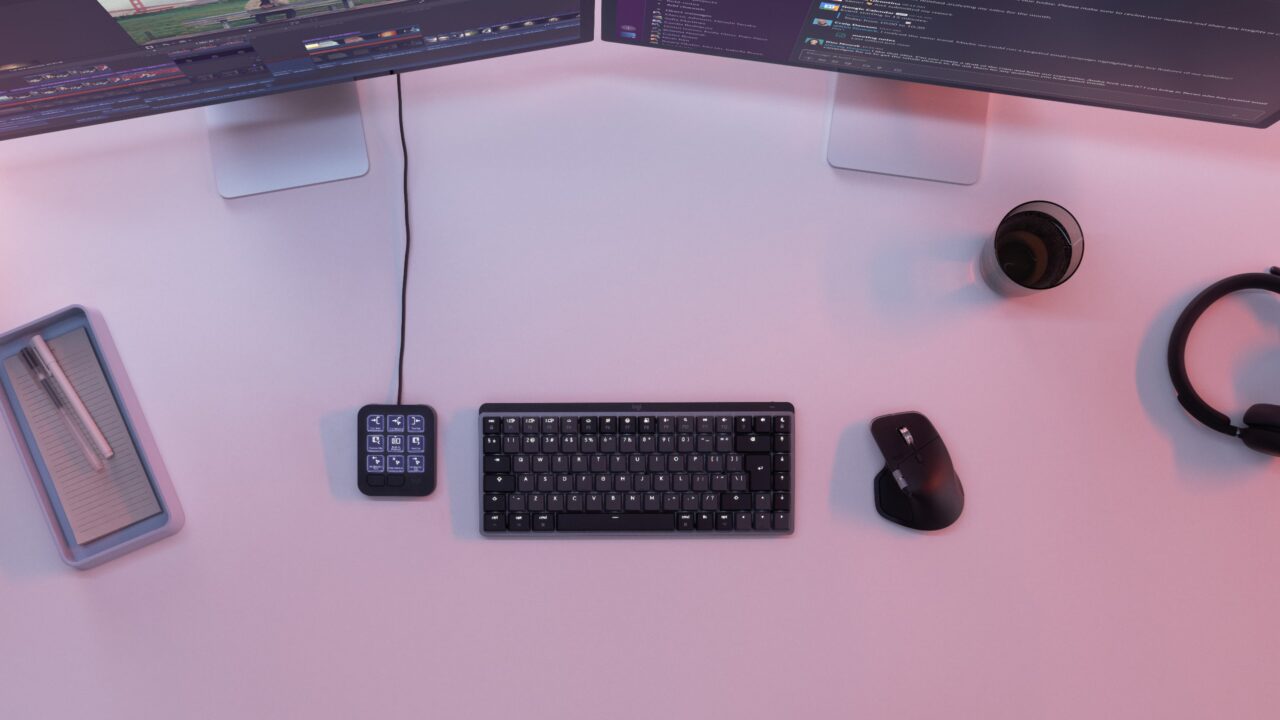 Logitech MX Keypad graphite à côté d'un clavier et d'une souris sur un bureau