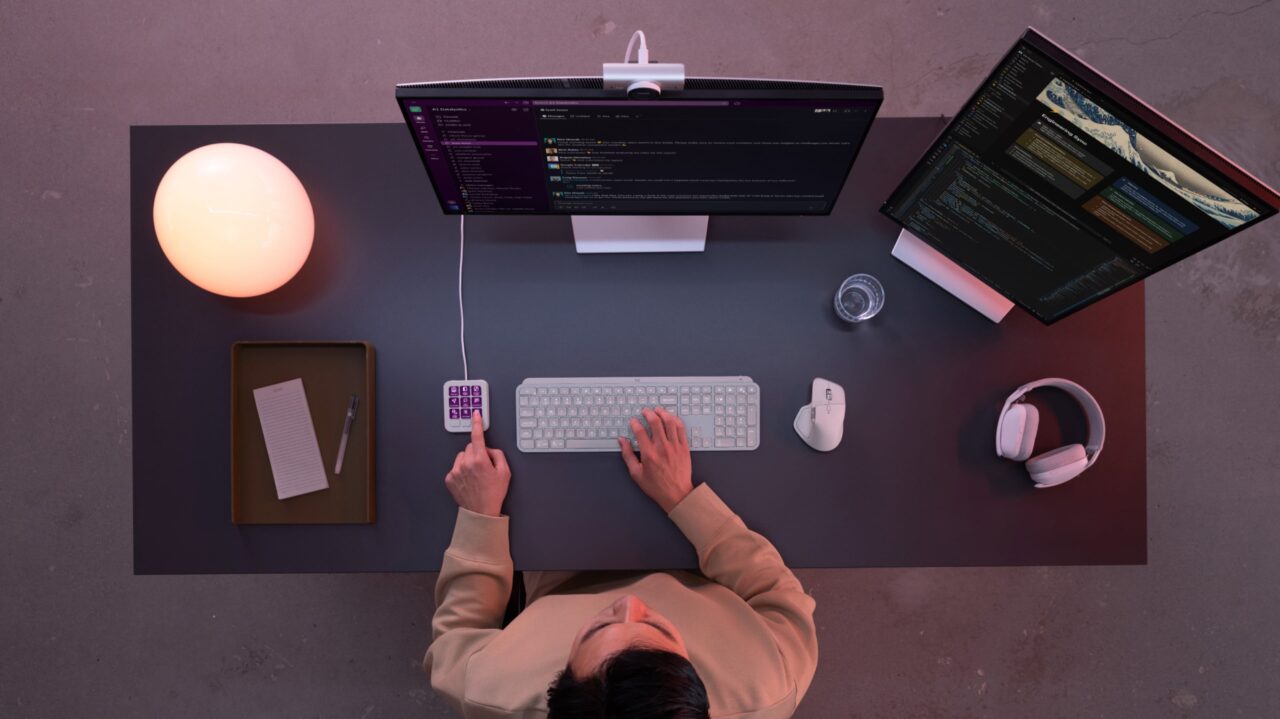 Logitech MX Keypad gris pâle sur un bureau vu du dessus avec deux écrans